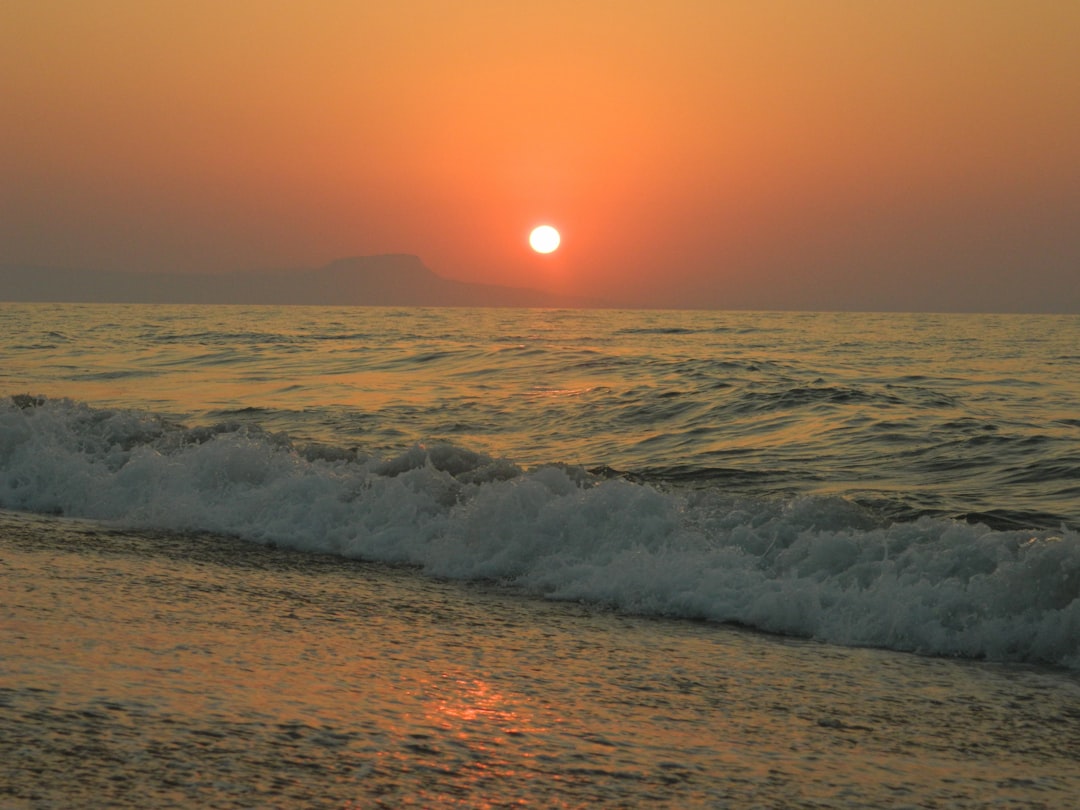 ocean waves crashing on shore during sunset