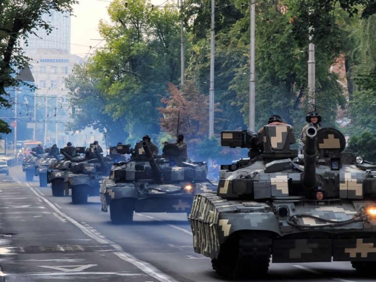 A group of tanks driving down a street