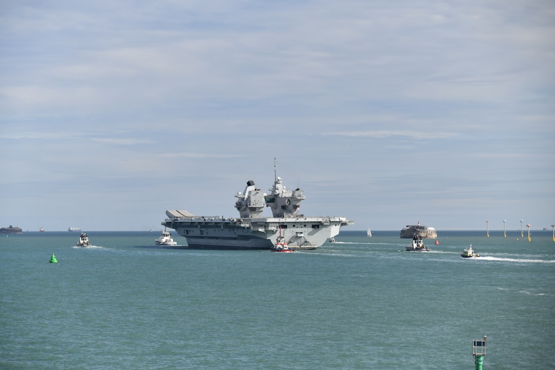 A large aircraft carrier sails on the ocean.