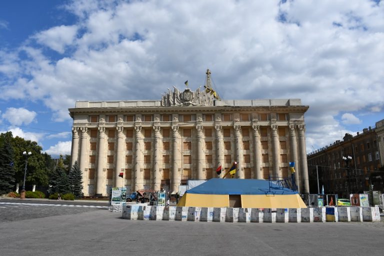Grand building with columns under a cloudy sky.
