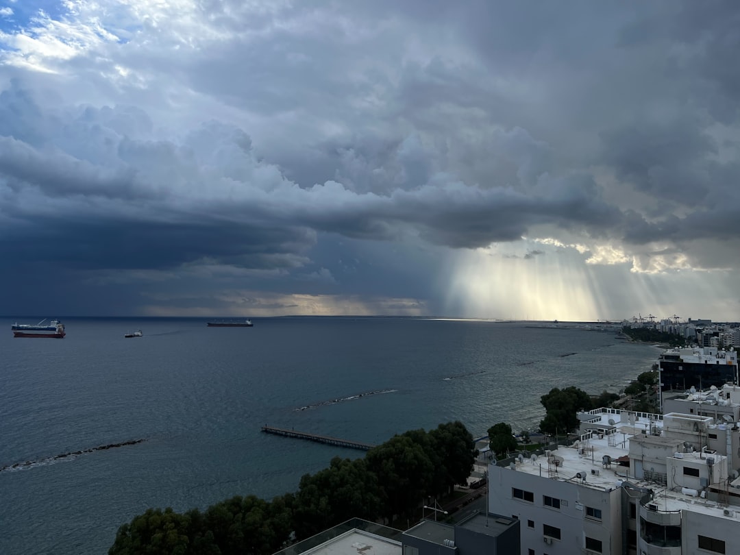 Sunbeams break through stormy clouds over the ocean.