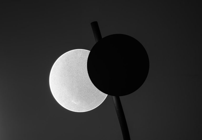 Two circles, one white and one black, on dark background