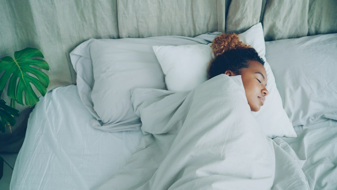 A young woman sleeping peacefully in a white bed